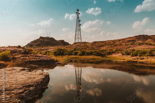 Fototapeta An antenna reflects on a lake in India