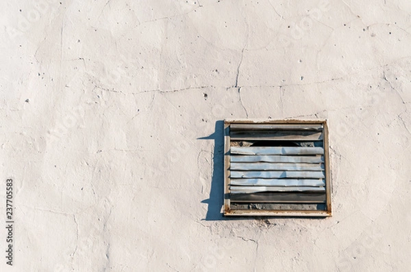 Fototapeta Old damaged rusty vent cover plate with grid on the wall of house or building for fresh clean air ventilation with free space