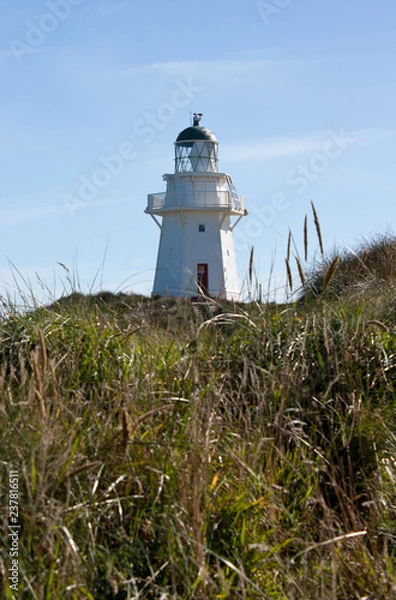 Fototapeta A lighthouse on a hill at Waipapa Point in the Catlins in the South Island in New Zealand