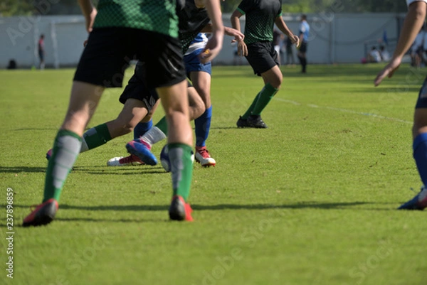 Fototapeta Football match in Boys' Under 18 years school soccer tournament. Players are in action of defending and attacking mode.