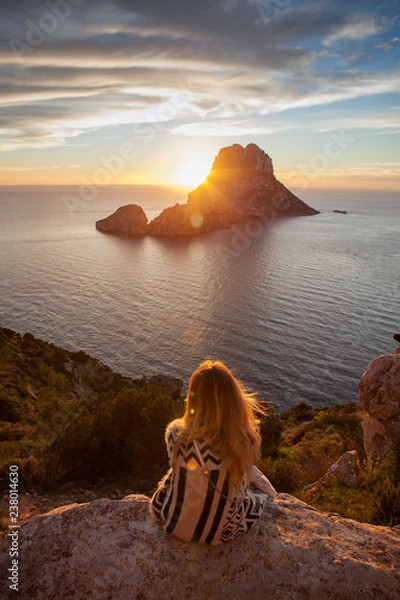 Obraz Woman back to the front watching a beautiful sunset at the beach. The beach is called Es Vedra