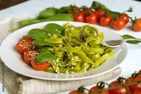 Fototapeta spinach tagliatelle with cherry tomatoes. proper diet.