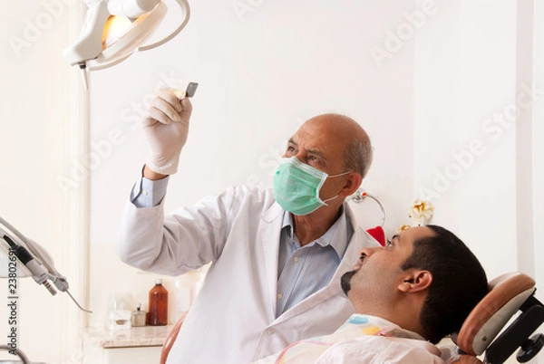 Obraz Dentist looking at an x-ray with a patient