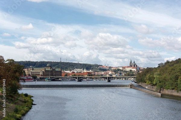 Obraz Prague panorama with Stefanik bridge, Vltava river, colorful rooftops, Petrin tower, Prague Castle and St. Vitus Cathedral in the distance, on a cloudy summer day