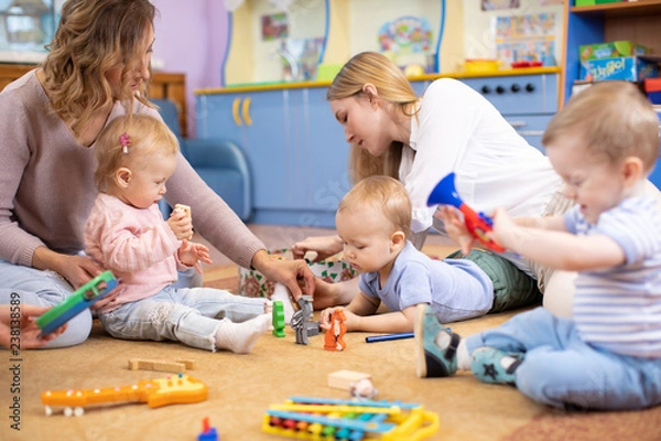 Fototapeta Przyjaciele z dziećmi bawiącymi się na podłodze w centrum Montessori