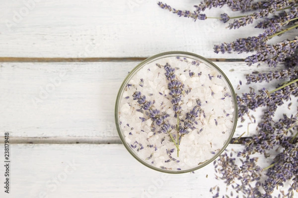 Obraz Natural herbal sea salt with aromatic lavender - perfect for relaxation. Cosmetic jars and bottles with salt, lavender flowers, bath bomb