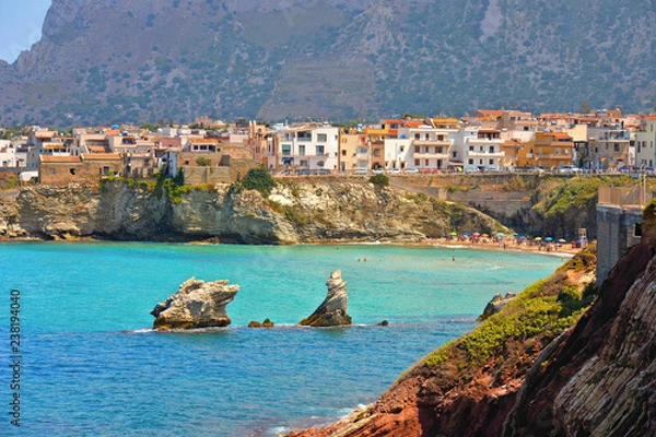 Fototapeta beautiful landscape with small coastal town Terrasini and beach calarossa with Faraglioni di Praiola with turquoise blue water and cloudy blue sky with mountains in background, Sicily Italy Palermo