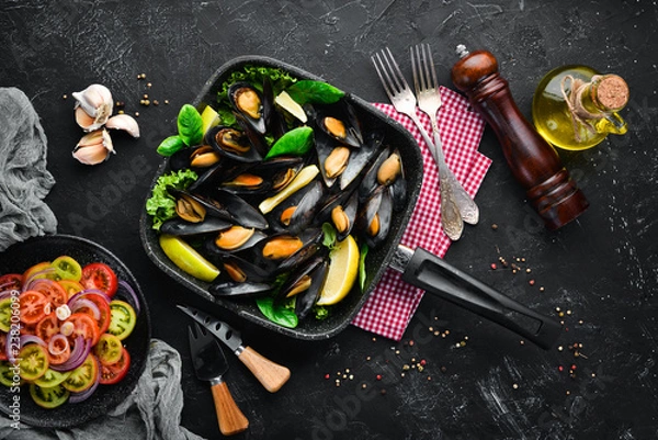 Fototapeta Fried mussels in a frying pan. Top view. Free space for your text. On the old background.