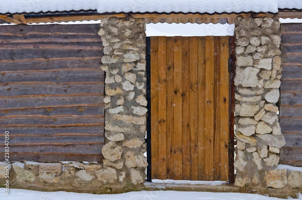 Obraz Оригинальный забор из каменных столбов и деревянных досок.