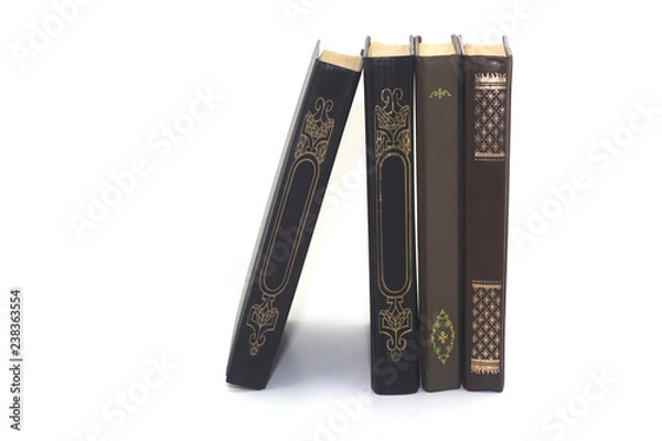 Fototapeta four old books standing on a white background close-up
