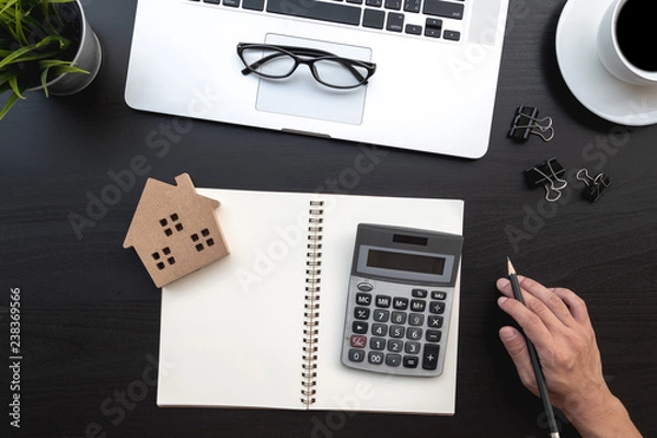 Fototapeta Flat lay of top view modern black wood desk work table with computer laptop and home property analysis office includes copyspace for add text or graphic