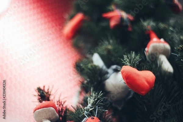 Fototapeta Heart shape Christmas Ornament on new year pine tree with red background for text