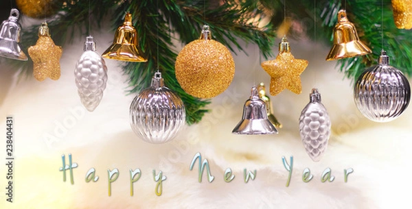 Fototapeta Shiny gold and silver christmas balls, stars and bells on white with pine tree for new year with happy new year text
