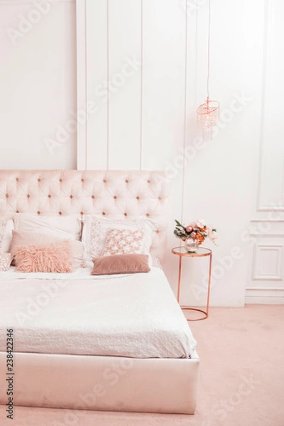 Fototapeta White-pink bedroom with large bed and many pillows on it