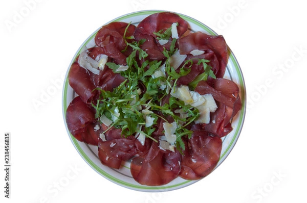 Obraz Flat lay. Piatto di bresaola con rucola e parmigiano sullo sfondo bianco. Cibo italiano.