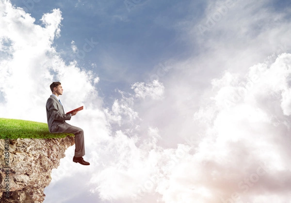 Fototapeta Student guy in suit with book in hands preparing for exam