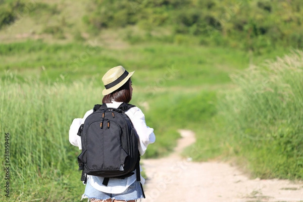 Fototapeta Young woman traveler with backpack enjoying and standing on the road of the mountains background, Koh Larn in Pattaya city, Chonburi Thailand