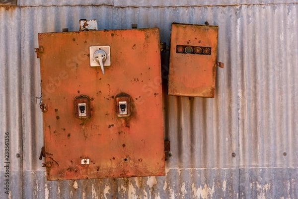 Fototapeta Old rusted iron electricity box with a textured metallic sheet background