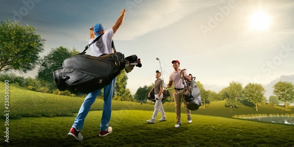 Obraz Three male golf players on professional golf course. Smiling golfers walking with golf clubs and golf bags