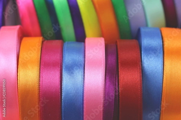 Fototapeta A lot of beautiful colored satin ribbons top view for decoration, gift wrapping and sewing in a fabric shop bright and colorful background close up