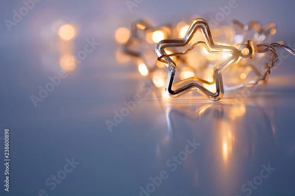 Fototapeta A stars shaped christmass garland on the table. Space for text