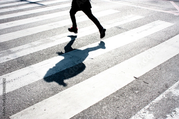 Fototapeta Blurry child and its shadow on zebra crossing