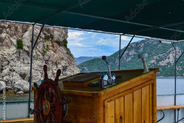 Obraz Ship steering wheel on the background of rocks and the sea