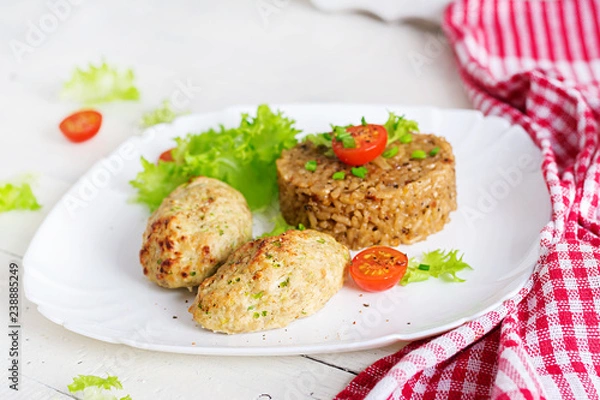 Fototapeta Homemade baked cutlets with rice on a table in a rustic style. Healthy food