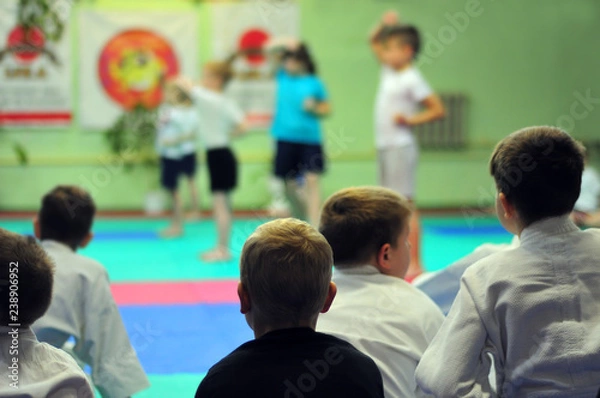 Fototapeta The first exam in karate. Exam for the right to wear a kimono.  For web pages or advertising printing. Persons blurred beyond recognition.