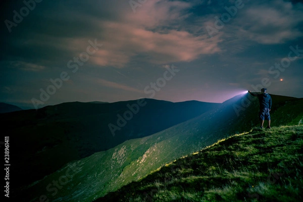 Obraz Searching with flashlight in mountains