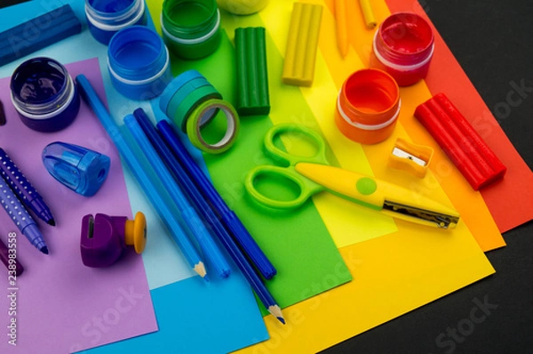 Obraz School accessories are laid out in the form of a rainbow. Black background.