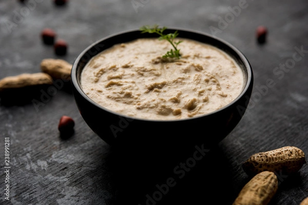 Fototapeta Healthy Peanut chutney made using Groundnut / Shengdana or mungfali. served in a small bowl with raw whole. Selective focus