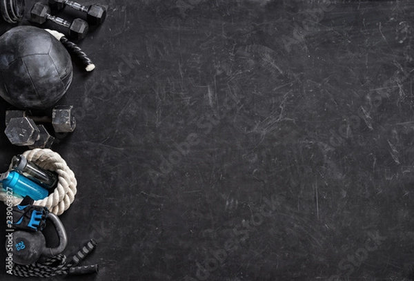 Obraz Sports equipment on a black background. Top view. Motivation
