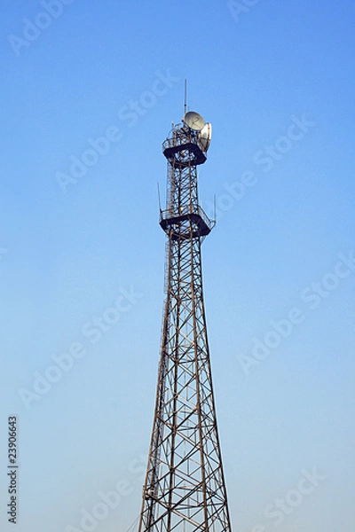 Fototapeta Communication tower over a deep blue sky.