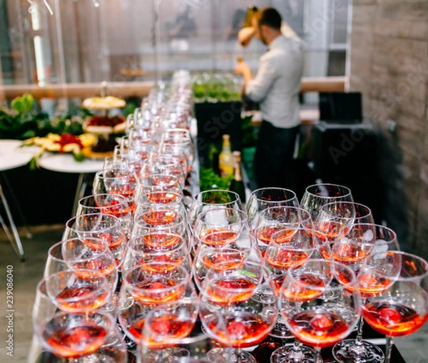 Fototapeta Red cocktail with strawberries. Strawberry daiquiri made with rum,brandy,lime juice, fresh strawberries,grenadine. Refreshing cocktails for a big company. A party. Soft focus.