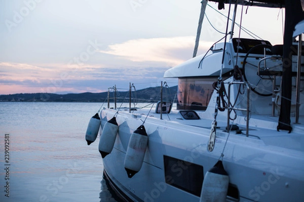 Fototapeta White catamaran in the sea, sunset, Greece
