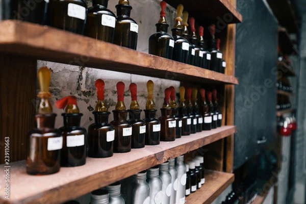 Obraz Chemical worker, Chemistry, Experiment, Vials. Close up amber color bottles on the shelf in old perfume laboratory. Flasks and examples of odor in the perfume shop.