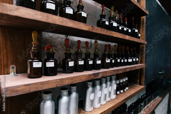 Obraz Chemical worker, Chemistry, Experiment, Vials. Close up amber color bottles on the shelf in old perfume laboratory. Flasks and examples of odor in the perfume shop.