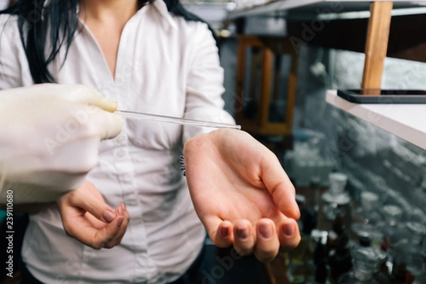 Fototapeta Lab / perfume laboratory closeup of hands in sterile gloves using a pipette. Close up amber color bottles on the shelf in old perfume laboratory. Flasks and examples of odor in the perfume shop.