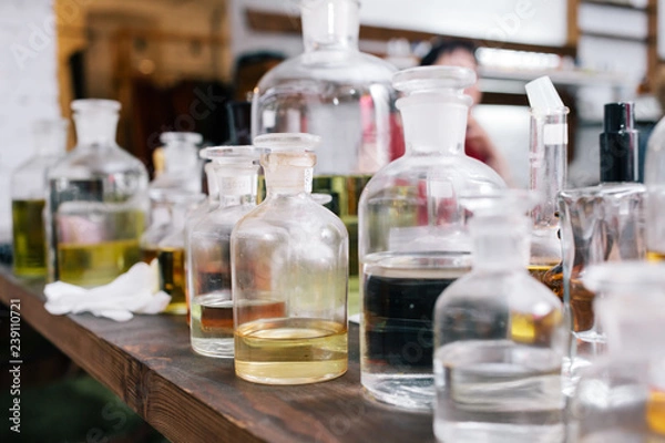Obraz Close up amber color bottles on the shelf in old perfume laboratory. Flasks and examples of odor in the perfume shop.