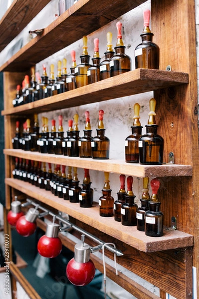Obraz Chemical worker, Chemistry, Experiment, Vials. Close up amber color bottles on the shelf in old perfume laboratory. Flasks and examples of odor in the perfume shop.