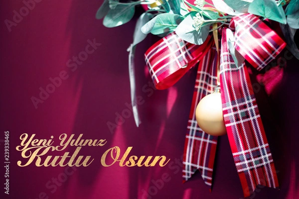 Fototapeta Red christmas gift ribbon on red background with text. Yeni yılınız kutlu olsun means happy new year