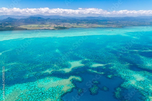 Fototapeta Aerial view of idyllic azure turquoise blue lagoon of West Coast barrier reef, with mountains far in the background, Coral sea, New Caledonia island, Melanesia, South Pacific Ocean.