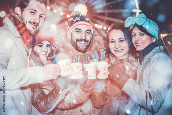 Fototapeta cheerful friends toasting with glow wine on the christmas market in brno next to the moravian square.