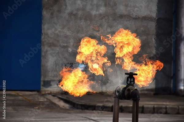 Fototapeta Gas pipeline leaks at the joints with the valve. Spark and Fire on the gas pipeline. An explosion at the gas pipeline.