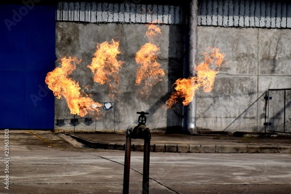 Fototapeta Gas pipeline leaks at the joints with the valve. Spark and Fire on the gas pipeline. An explosion at the gas pipeline.