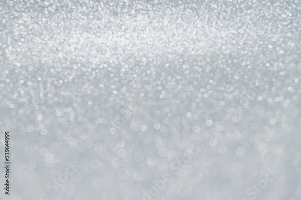 Fototapeta Delicate white glitter bokeh background. Glowing texture.