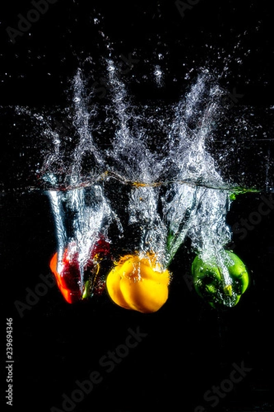 Obraz Fresh colourful bell pepper splashing in water on black background.