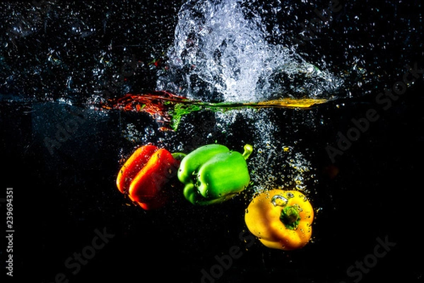 Obraz Fresh colourful bell pepper splashing in water on black background.