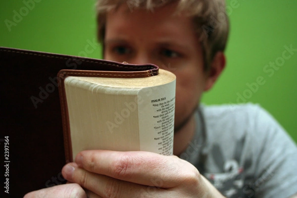 Obraz young man reading small bible